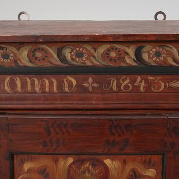 A wall cabinet, dated 1843.