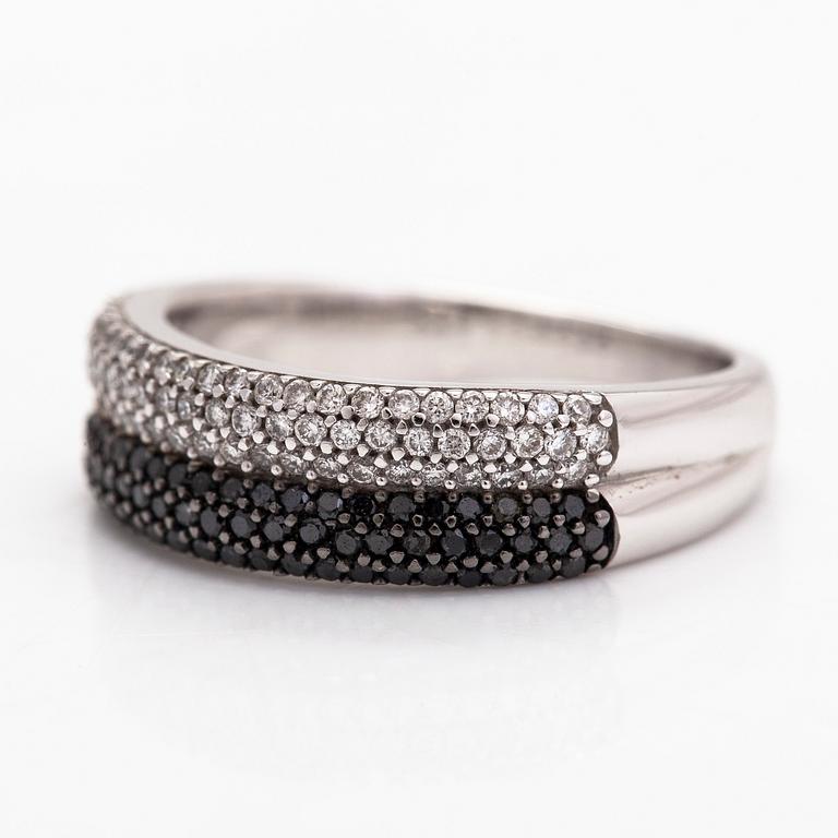 An 18K white gold ring with black and white diamonds.