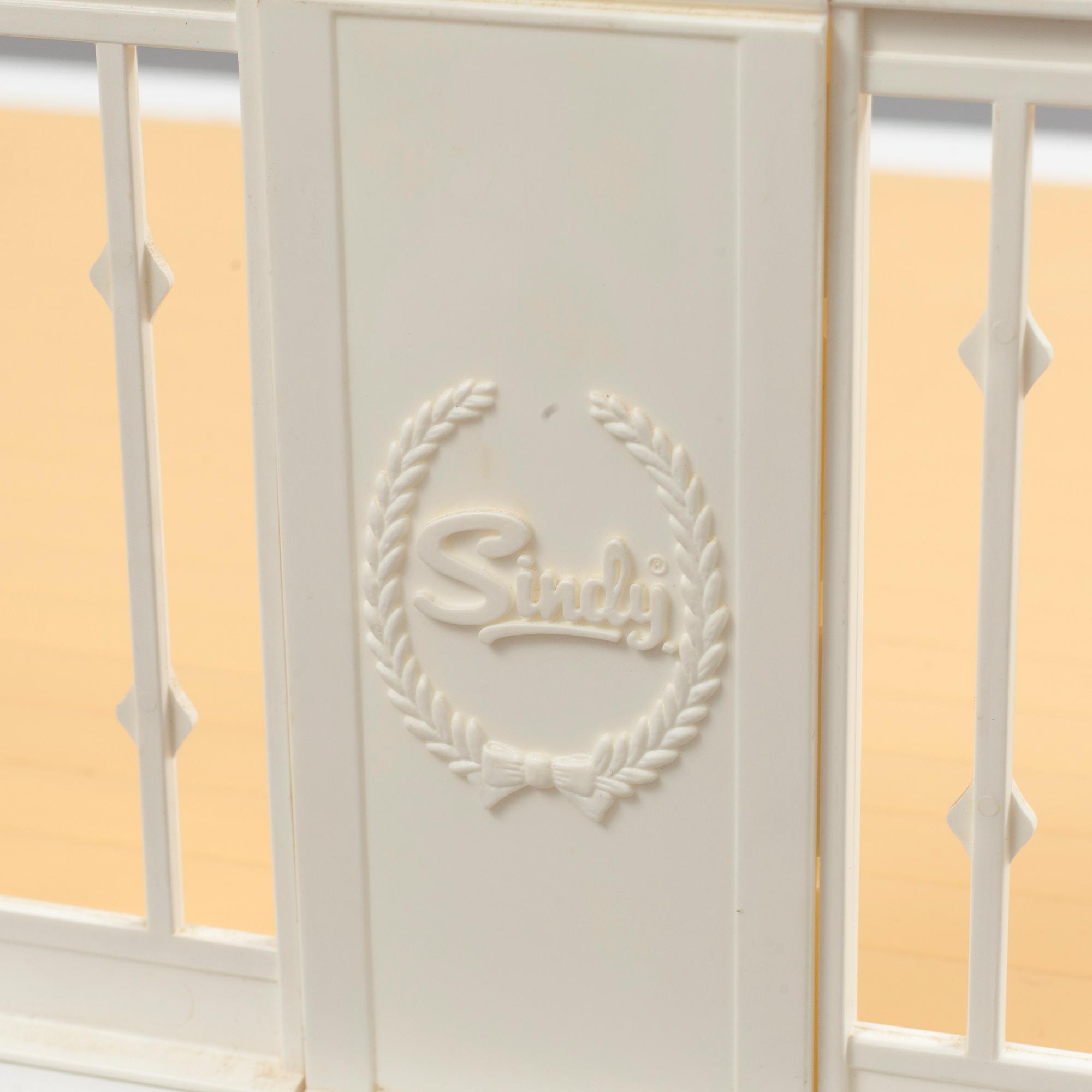 A plastic doll's house with six dolls, furniture and clothes, 20th century.