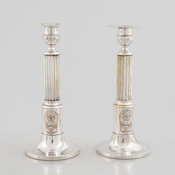 A pair of candlesticks and a commemorative pin from the Olympic Games in Stockholm 1912.