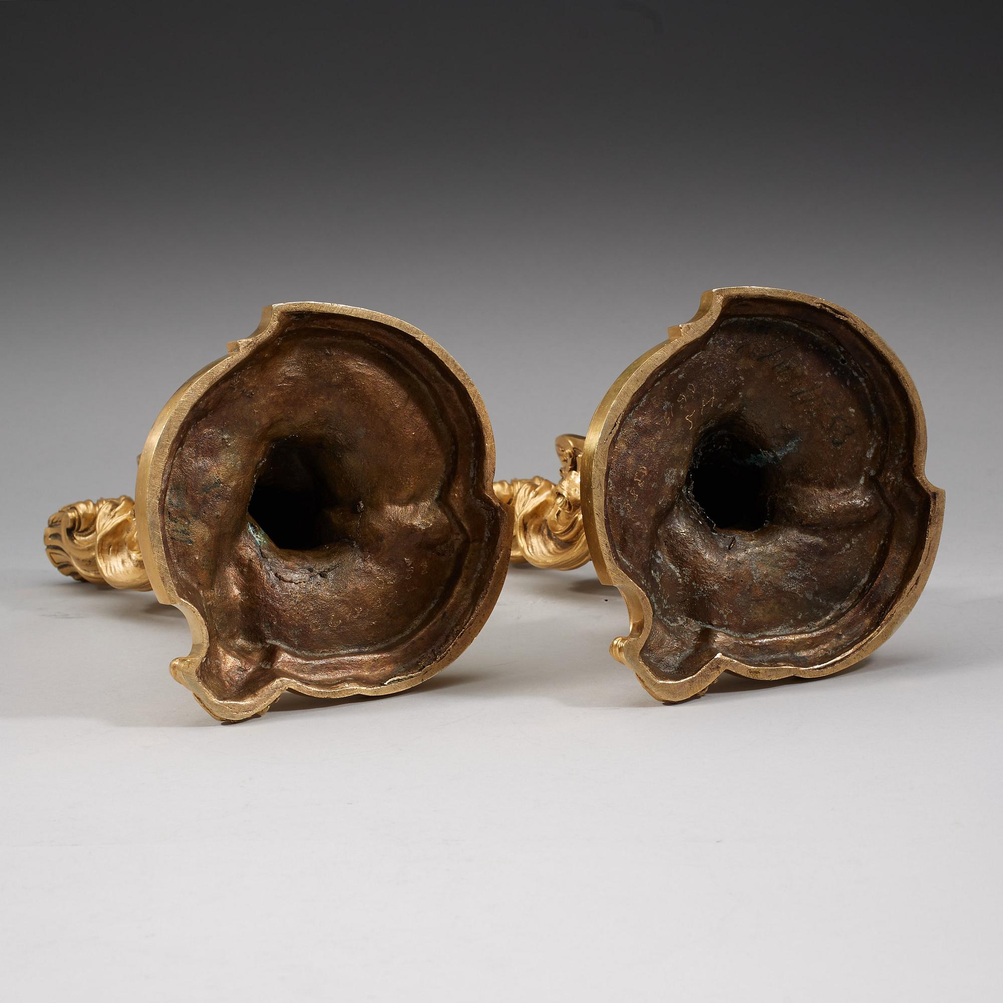 A pair of Louis XV 18th century gilt bronze candlesticks after the model by Juste-Aurèle Meissonnier.