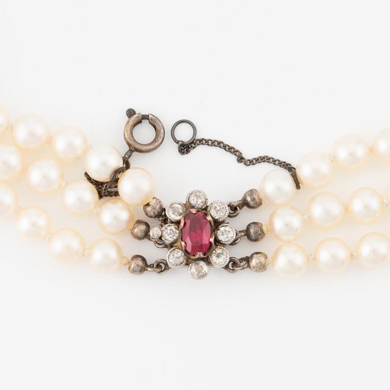 Pearl necklace, three strands, with graduated cultured pearls, gold set with old-cut diamonds and synthetic ruby.