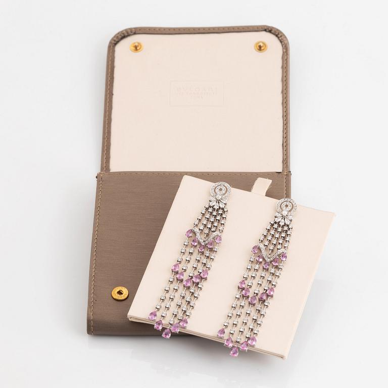 A pair of 18K white gold earrings set with faceted pink sapphires and round brilliant-cut diamonds.