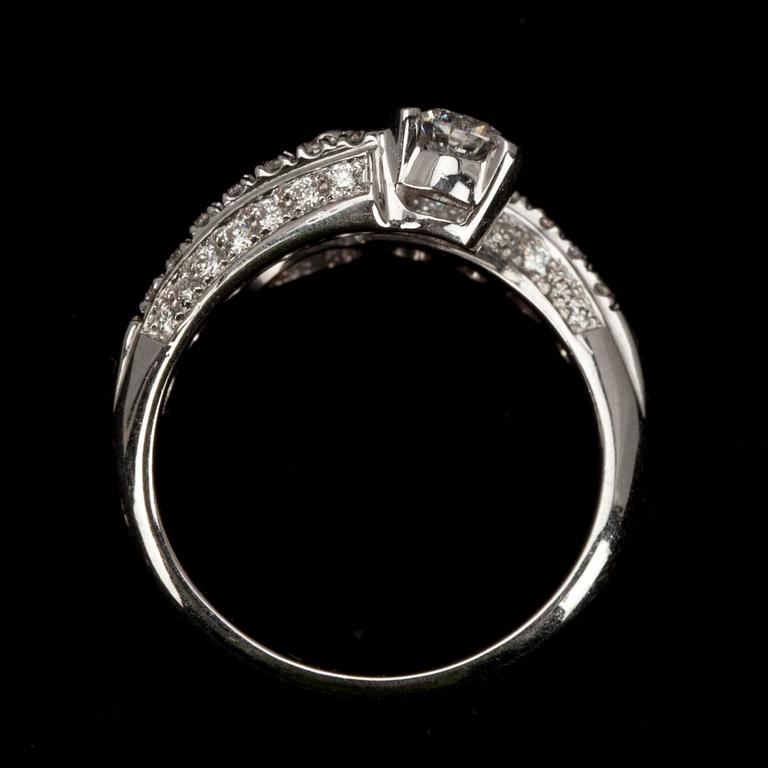 RING, vitguld 18K, briljantslipad diamant 0,23 ct, 42 st. små diamanter, safir 0,20 ct. Vikt 5,8 g.