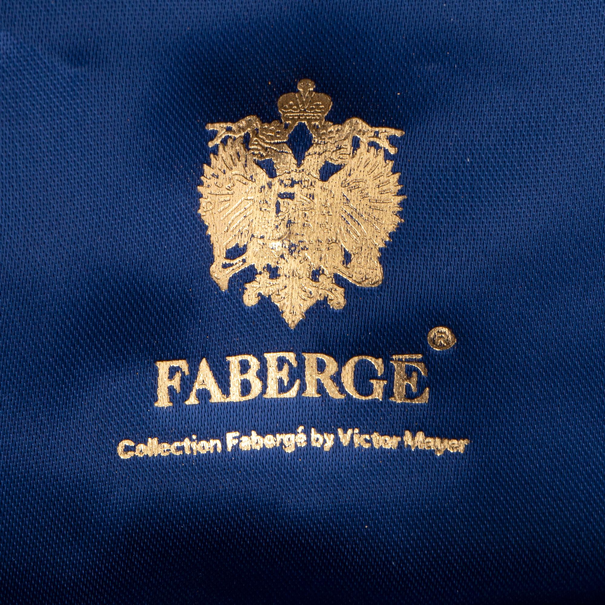 FABERGÉ-ÄGG, 18K guld med blå emalj och runda briljantslipade diamanter, med kedja, med etui.