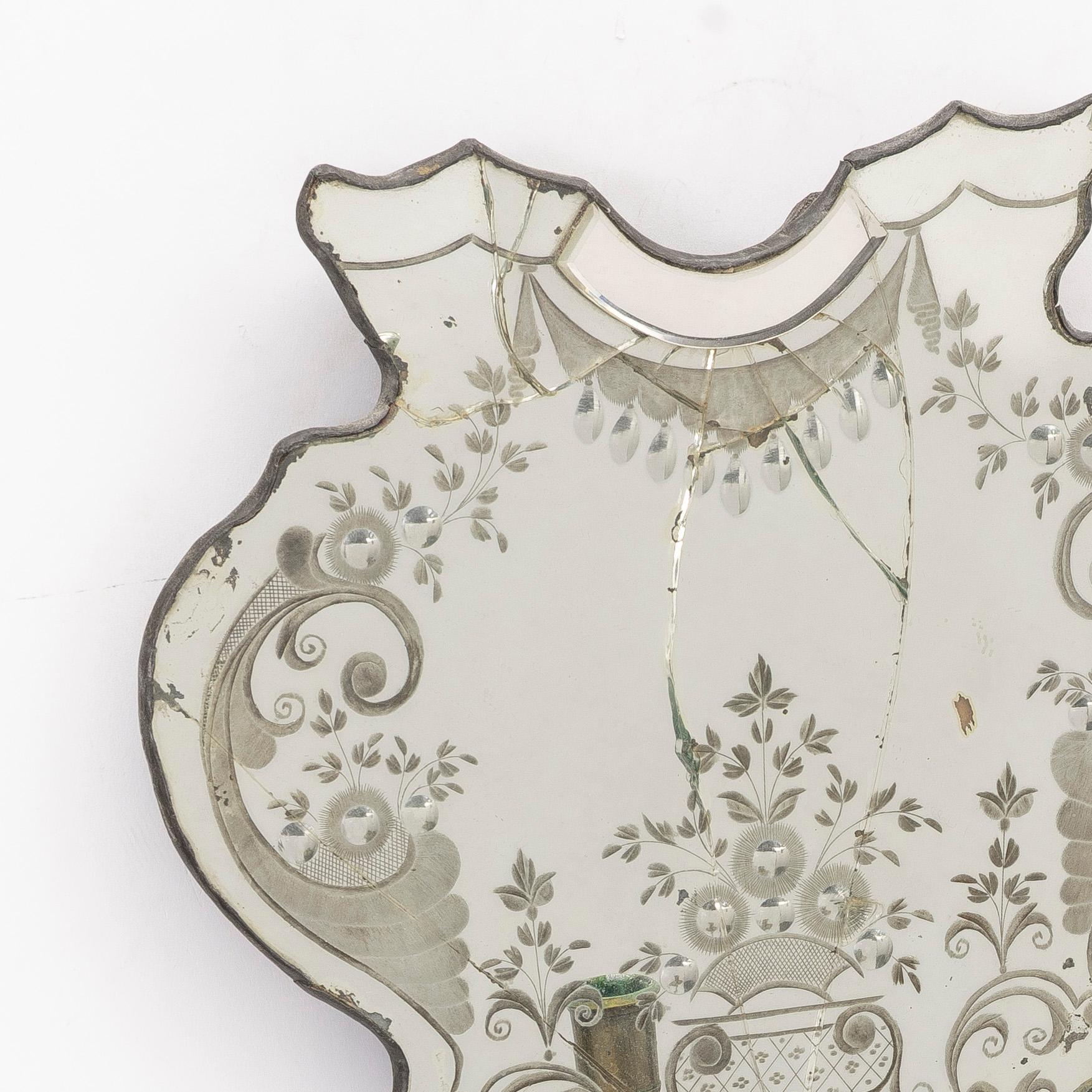 A North European rococo one-branch engraved glass girandole mirror, mid 18th century.