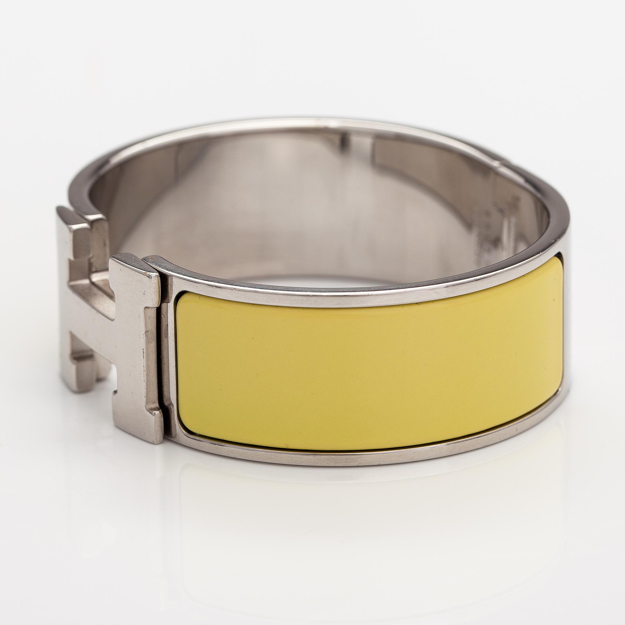 Hermès, A "Click H" bracelet made of metal and yellow enamel. Marked Hermès, ST1105, S, Made in France.