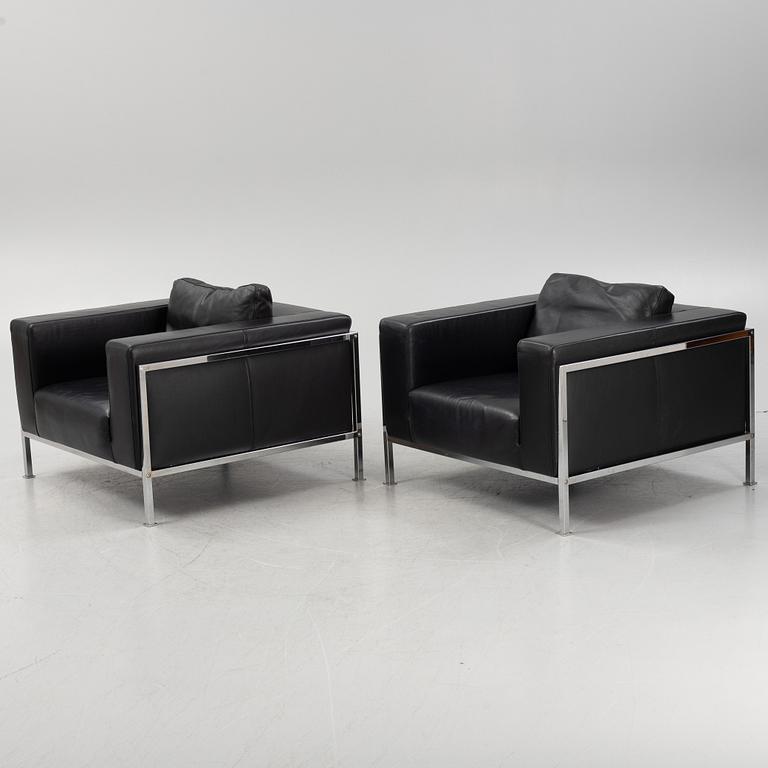 A pair of leather upholstered lounge chairs,