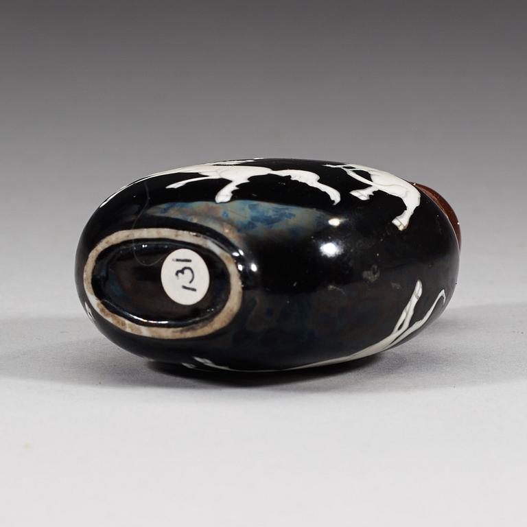 An enamelled porcelain snuff bottle with stopper, Qing dynasty (1644-1912).