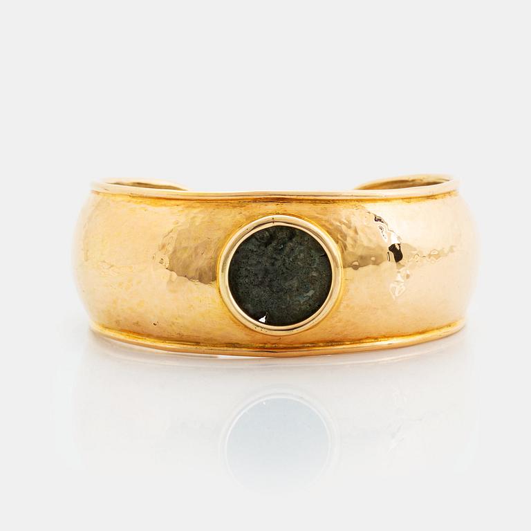 An 18K gold bangle set with an ancient coin.