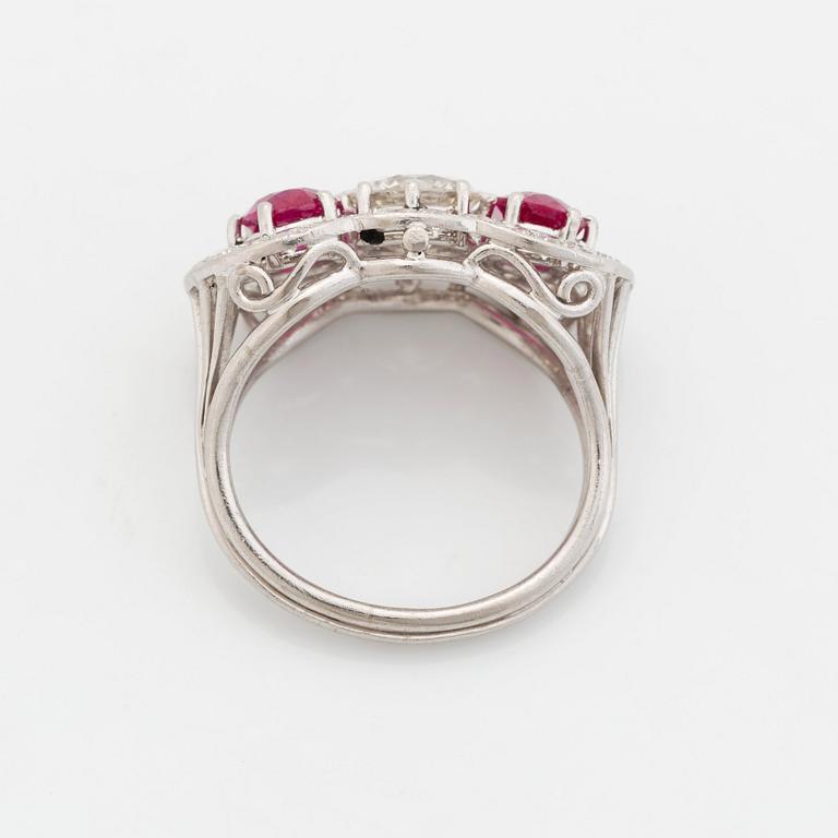 An 18K white gold ring set with faceted rubies and a round brilliant-cut diamond and eight-cut diamonds.