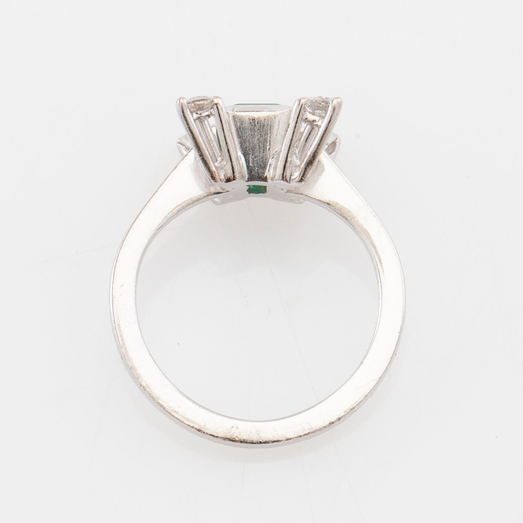 Ring in 18K white gold with a step-cut emerald and round brilliant-cut diamonds.