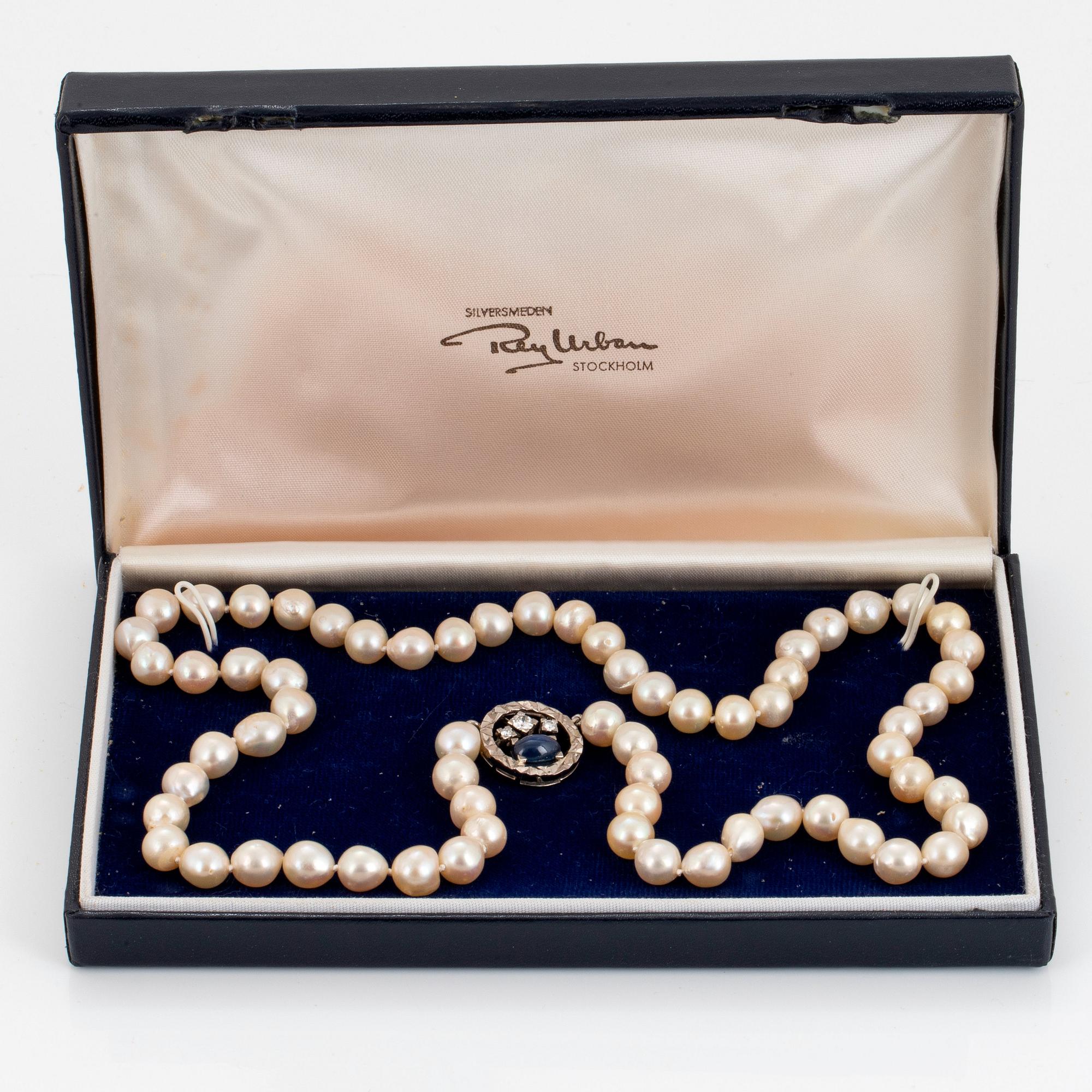 A Rey Urban cultured pearl necklace with an 18K white gold clasp set with a cabochon-cut sapphire.