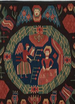 CARRIAGE CUSHION. "The Annunciation". Tapestry weave. 52 x 96,5 cm. Scania, Sweden, first half of the 19th century.