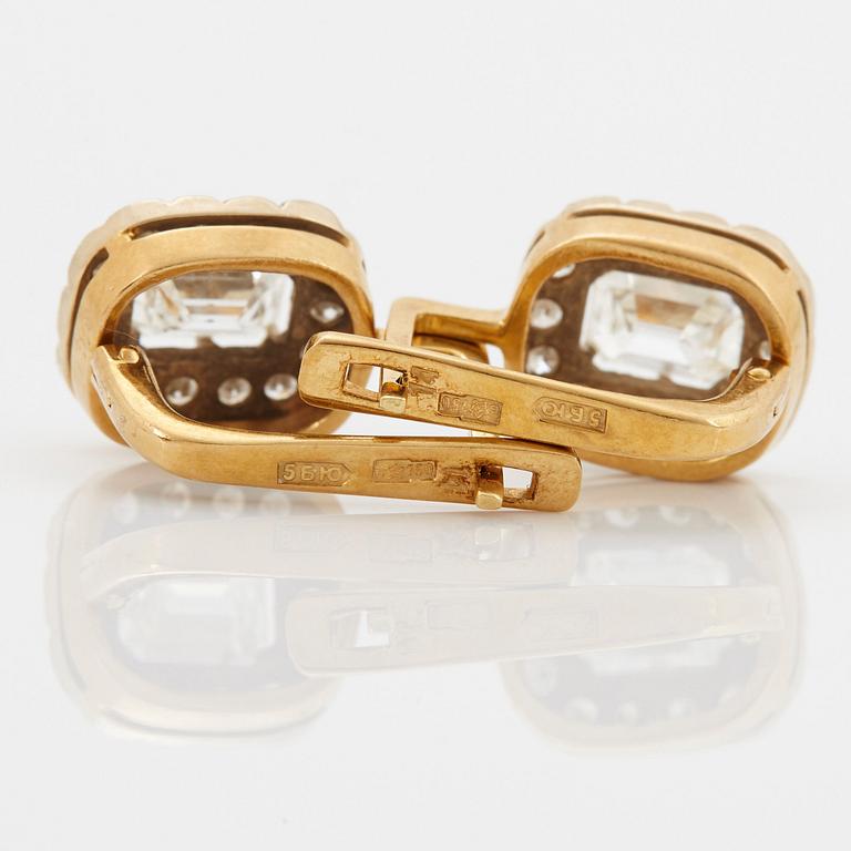 A pair of earrings in 18K gold set with emerald-cut diamonds.