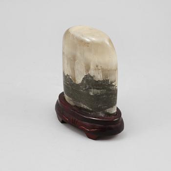 STEN, på träsockel.