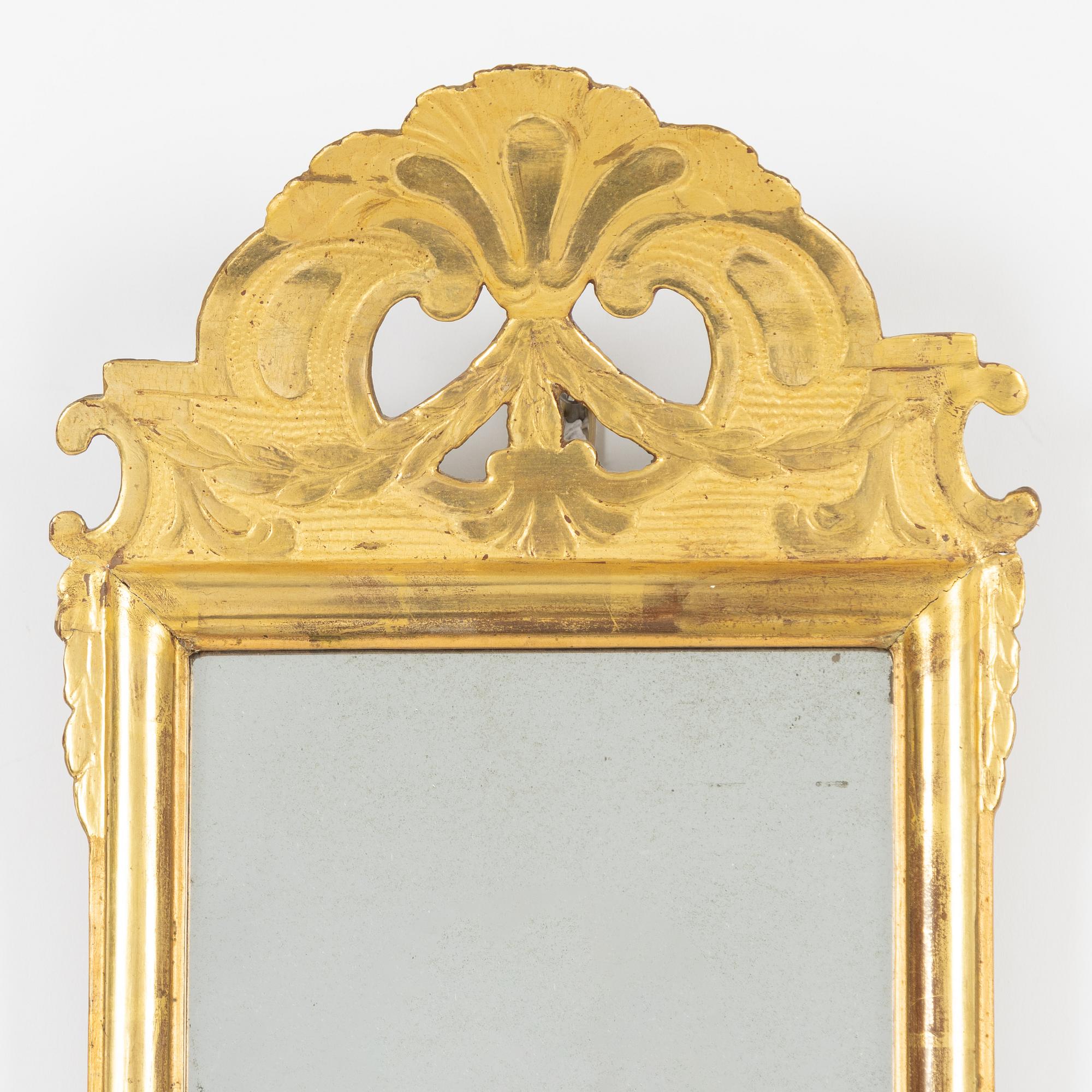 A giltwood rococo mirror by J. Schürer (master in Stockholm 1769).