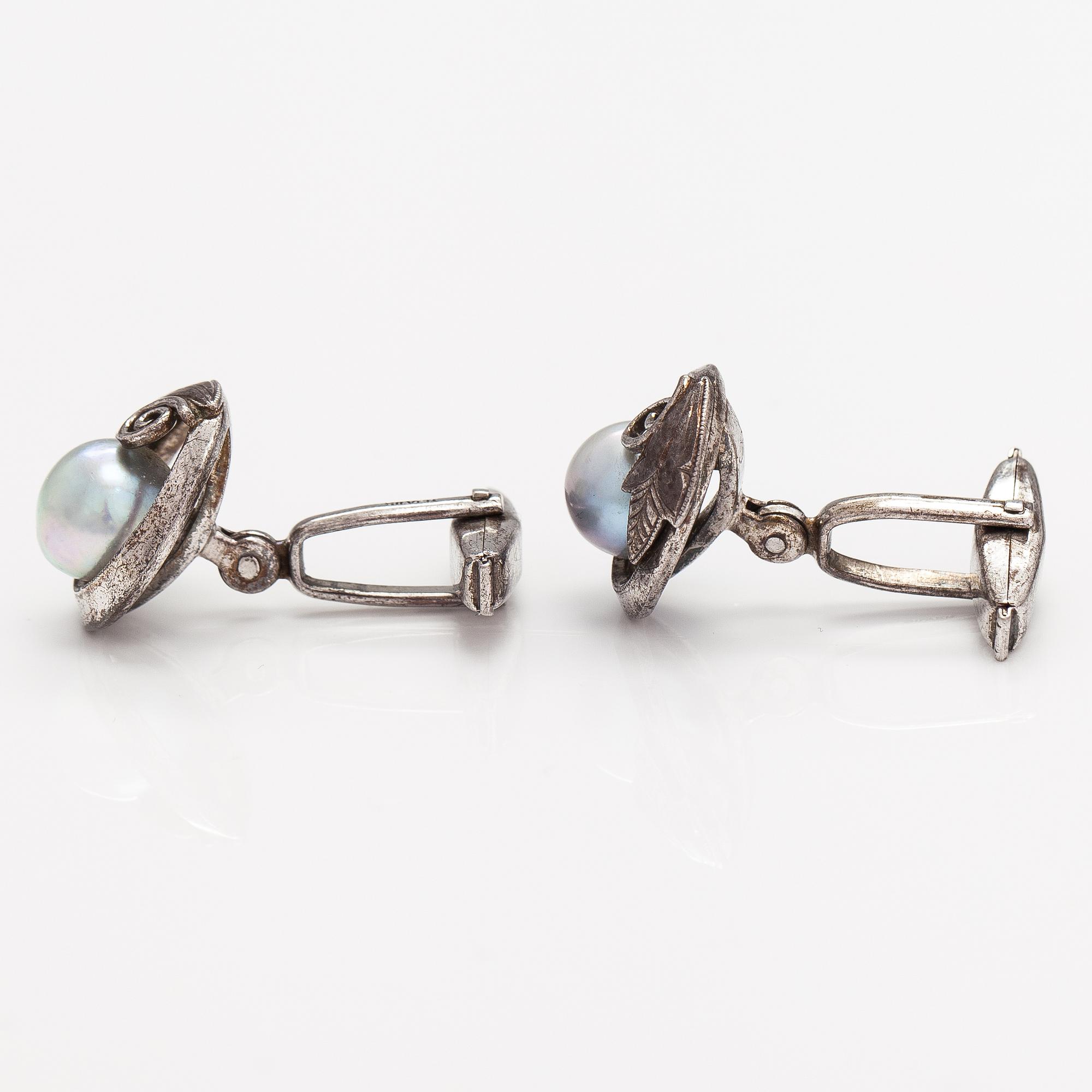 A pair of silver cufflinks with cultured baroque/Akoya pearls.
