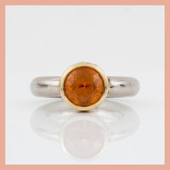 An orange spessartine garnet, ca 4.00 cts, and brilliant-cut diamond ring. Total carat weight of diamonds circa 0.12 ct.