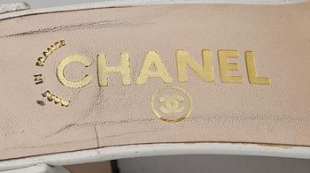 A pair of white leather slip-in by Chanel.