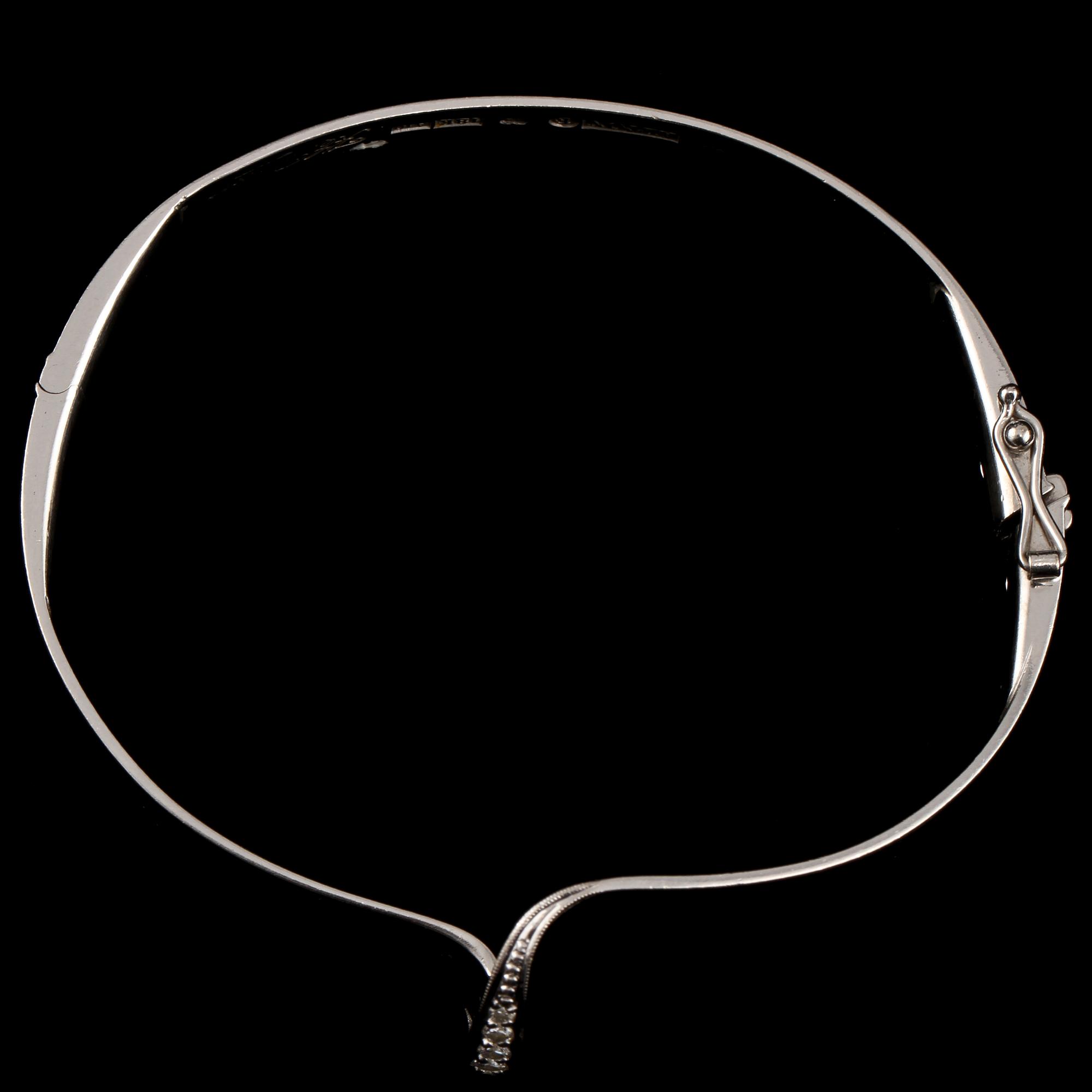 ARMRING, 18k vitguld med 7 briljantslipade diamanter, tot 0.17 ct, KE Palmberg, Alton, Falköping, 1975. Vikt 21 g.