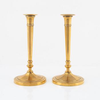 A pair of candlesticks in gilded bronze. Directoire style, around 1800, France.