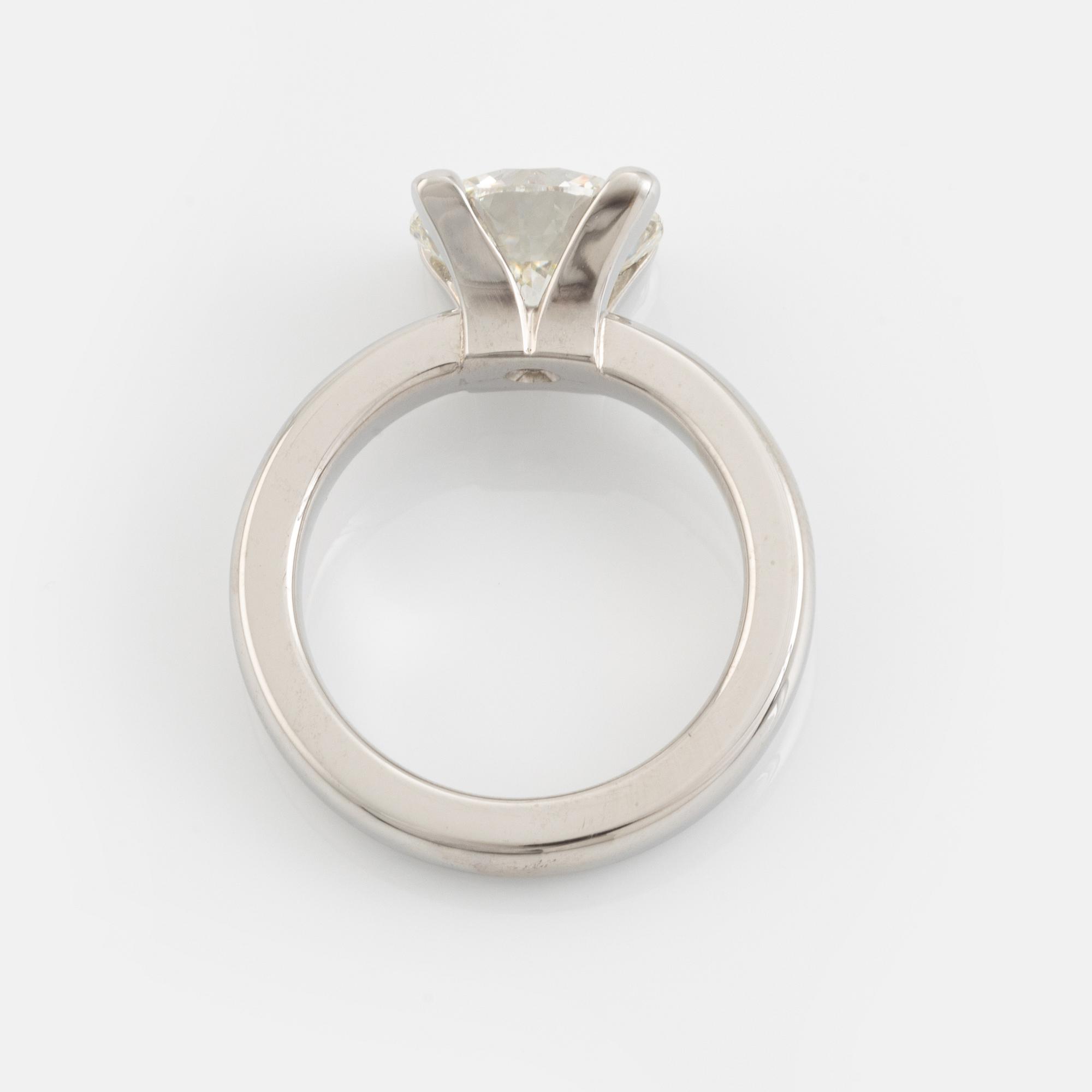 An 18K white gold ring set with a round brilliant-cut diamond.