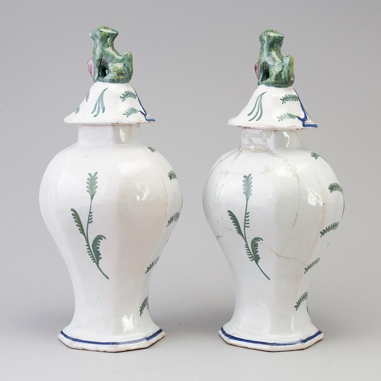 A pair of faience lidded urns, 18th/19th century.