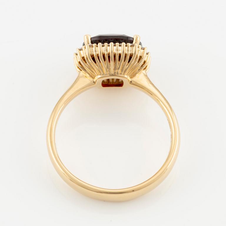 Ring in 18K gold with a faceted garnet and round brilliant-cut diamonds.