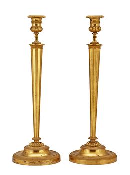 676. A pair of French Empire early 19th century candlesticks.