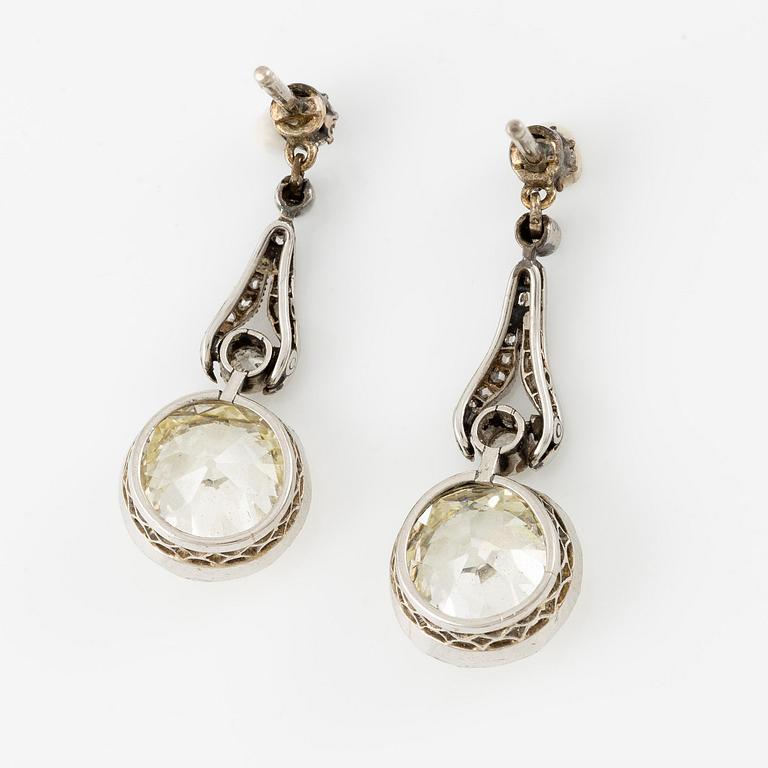 A pair of platinum earrings with two old-cut diamonds.