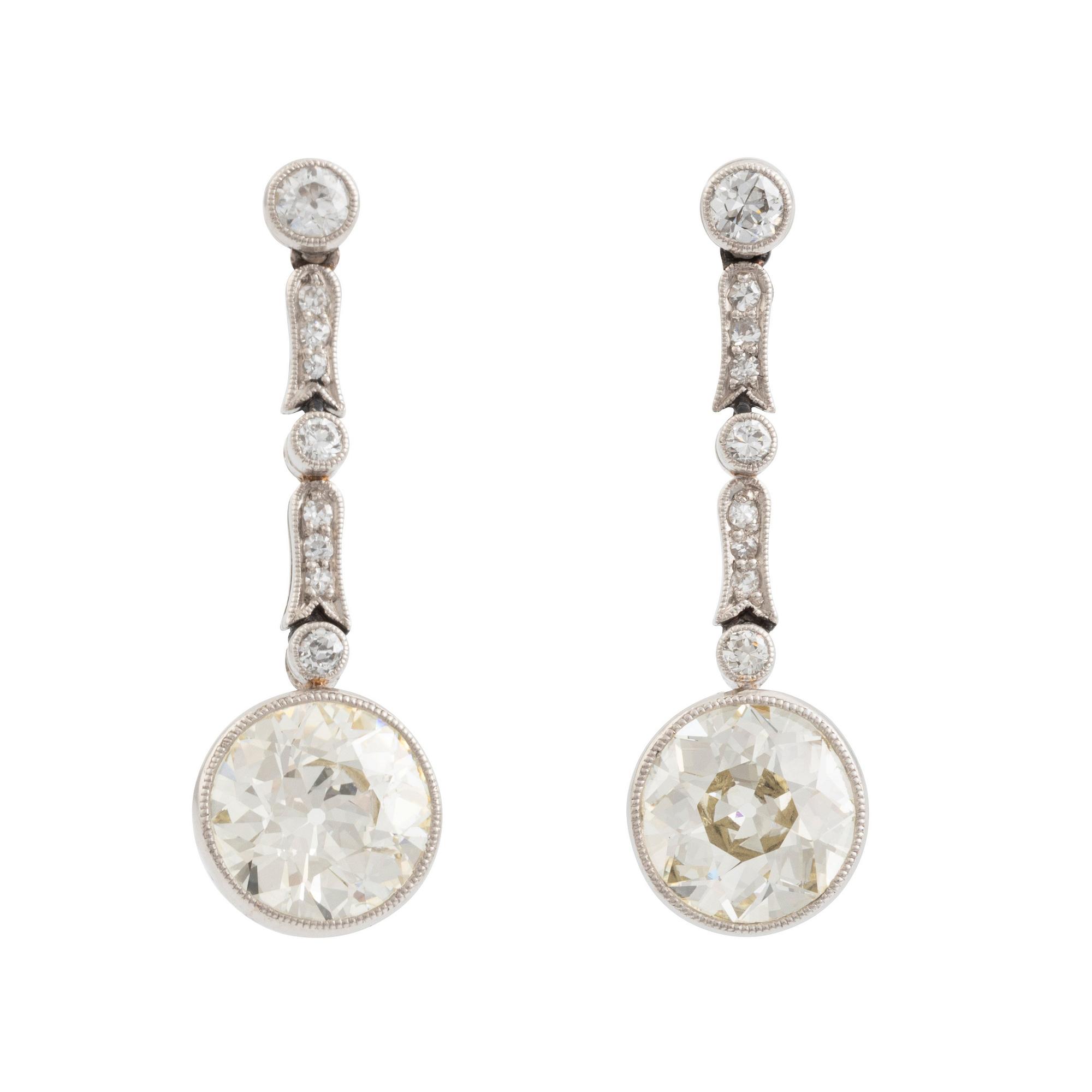 A pair of platinum earrings with two larger old-cut diamonds.