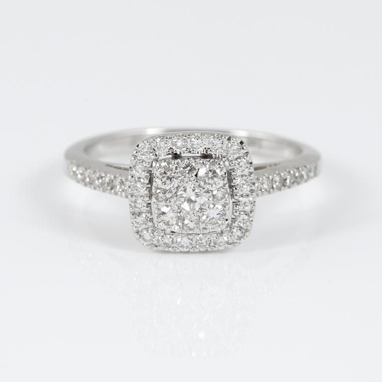 RING, 14K vitguld med central prinsesslipad diamant omgiven av briljantslipade diamanter tot ca 0,71 ct. Vikt 3,22 g.
