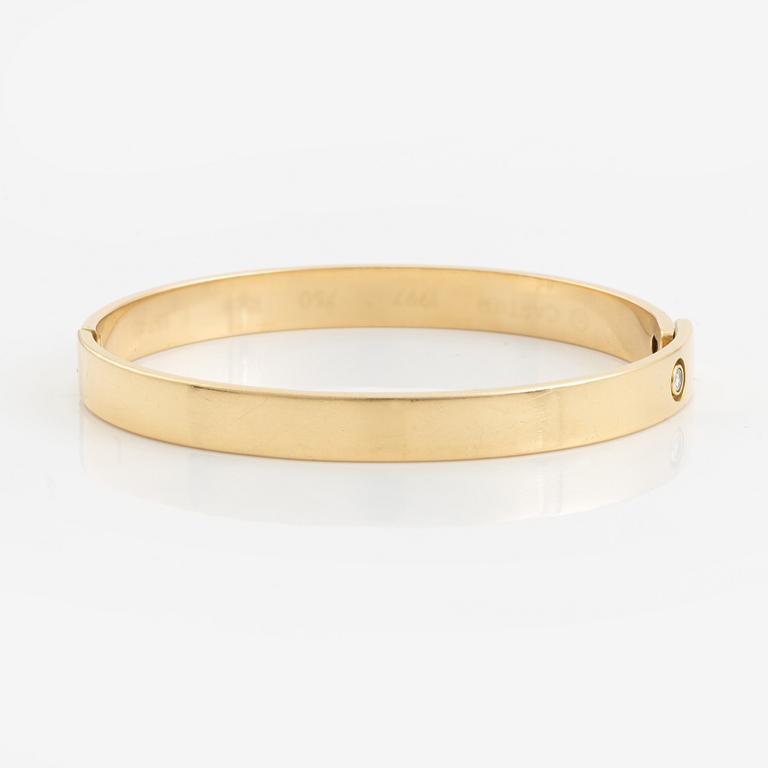 A Cartier "Anniversary Bracelet" in 18K gold set with a round brilliant-cut diamond.