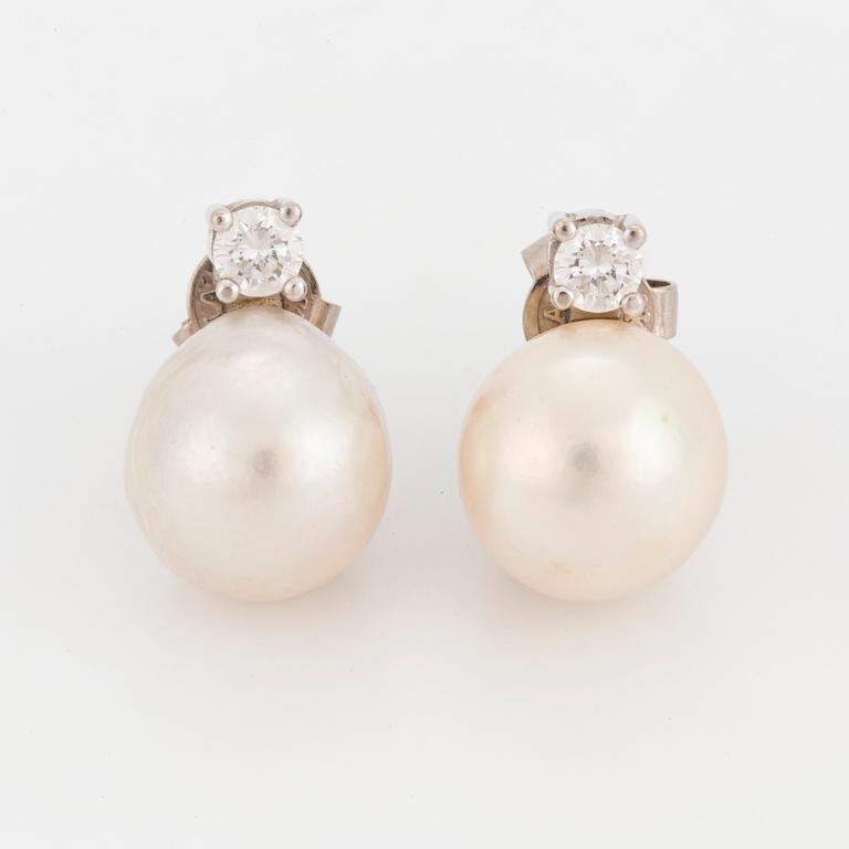 A pair of earrings set with cultured pearls and round, brilliant-cut diamonds.