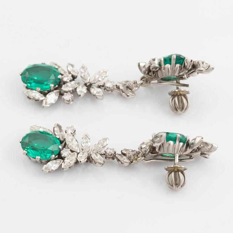 A pair of 18K white gold earrings set with round brilliant- and navette-cut diamonds and green synthetic stones.