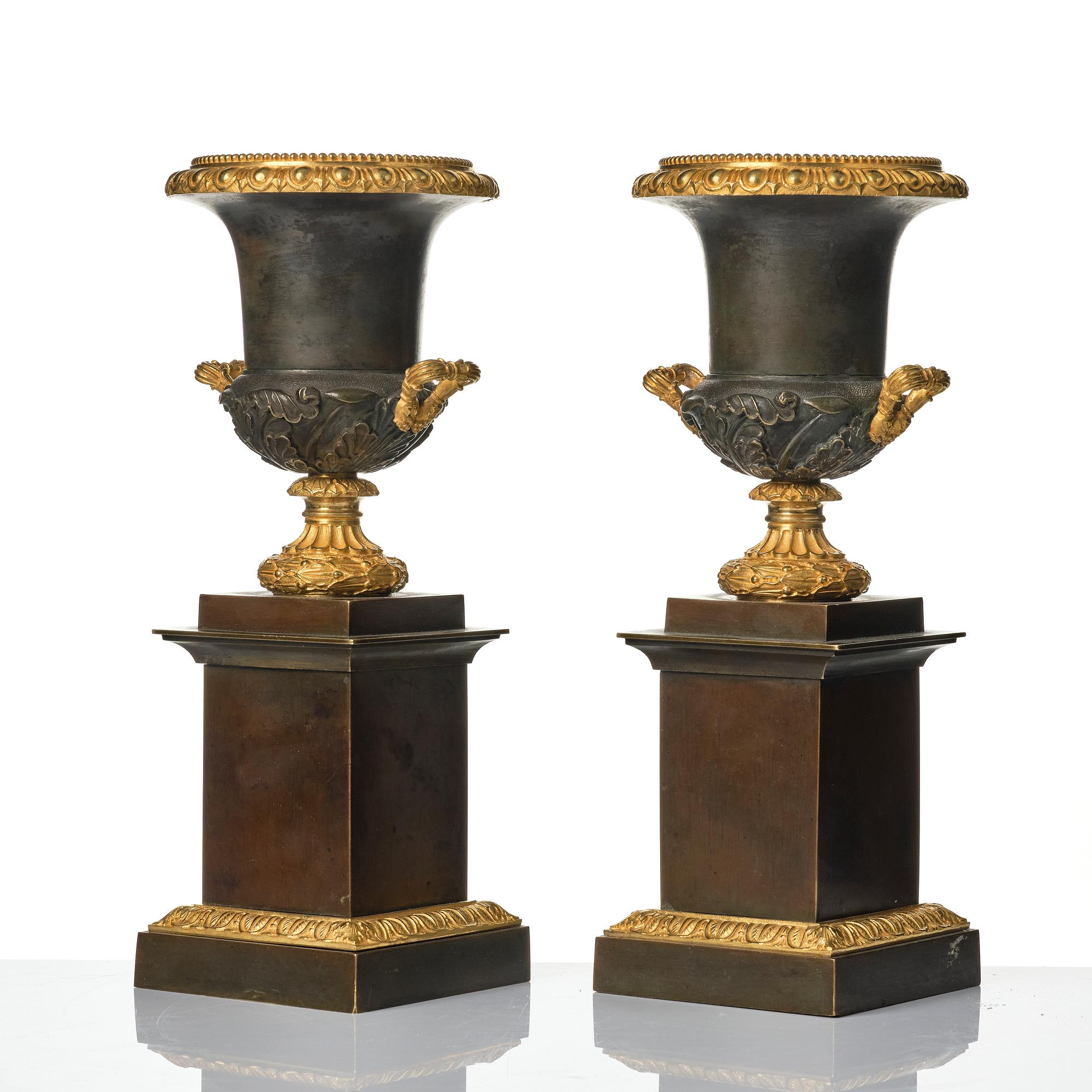 A pair of French Louis Philippe gilt and patinated bronze urns, first part 19th century.