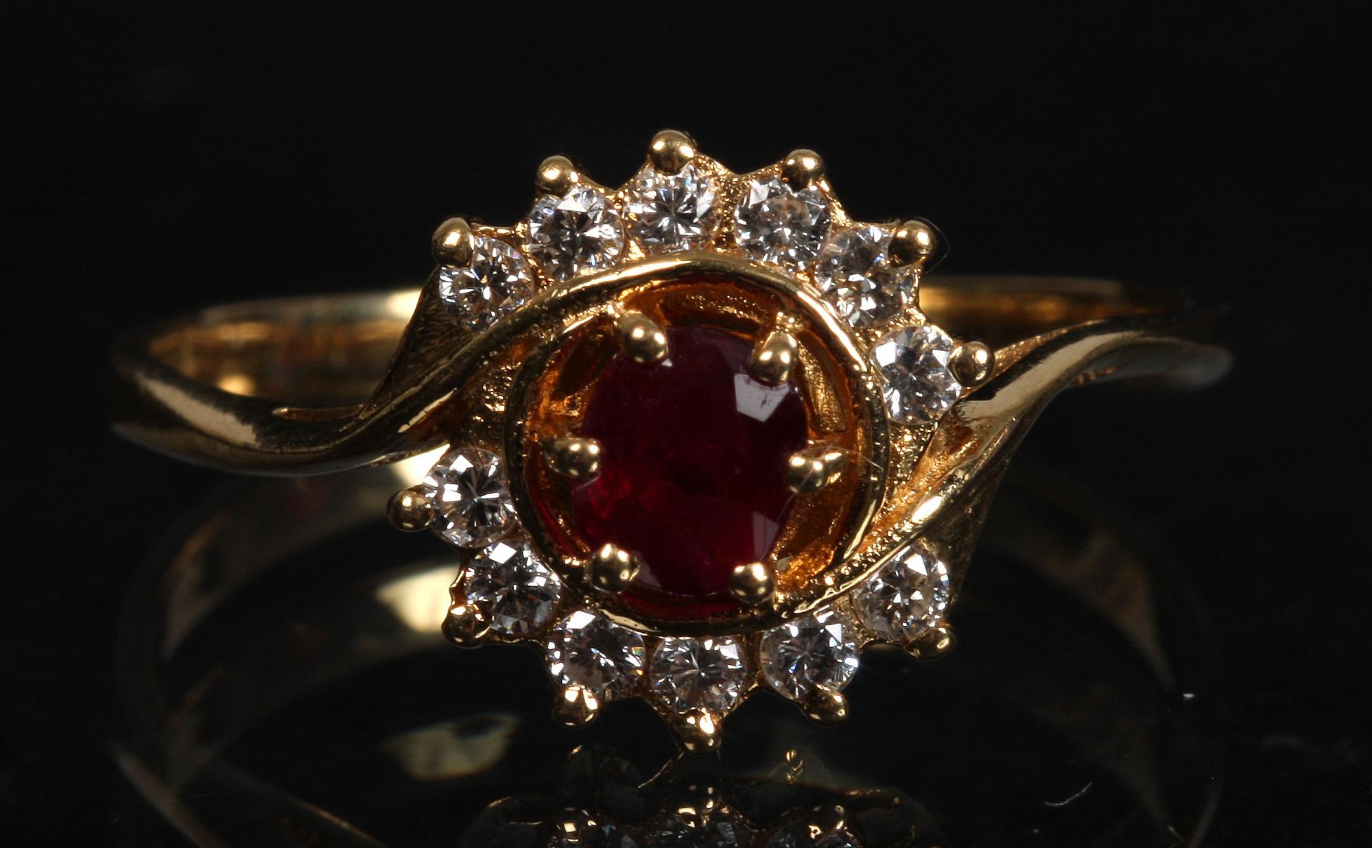 RING, 18 K guld, med tolv briljanter samt en rubin.
