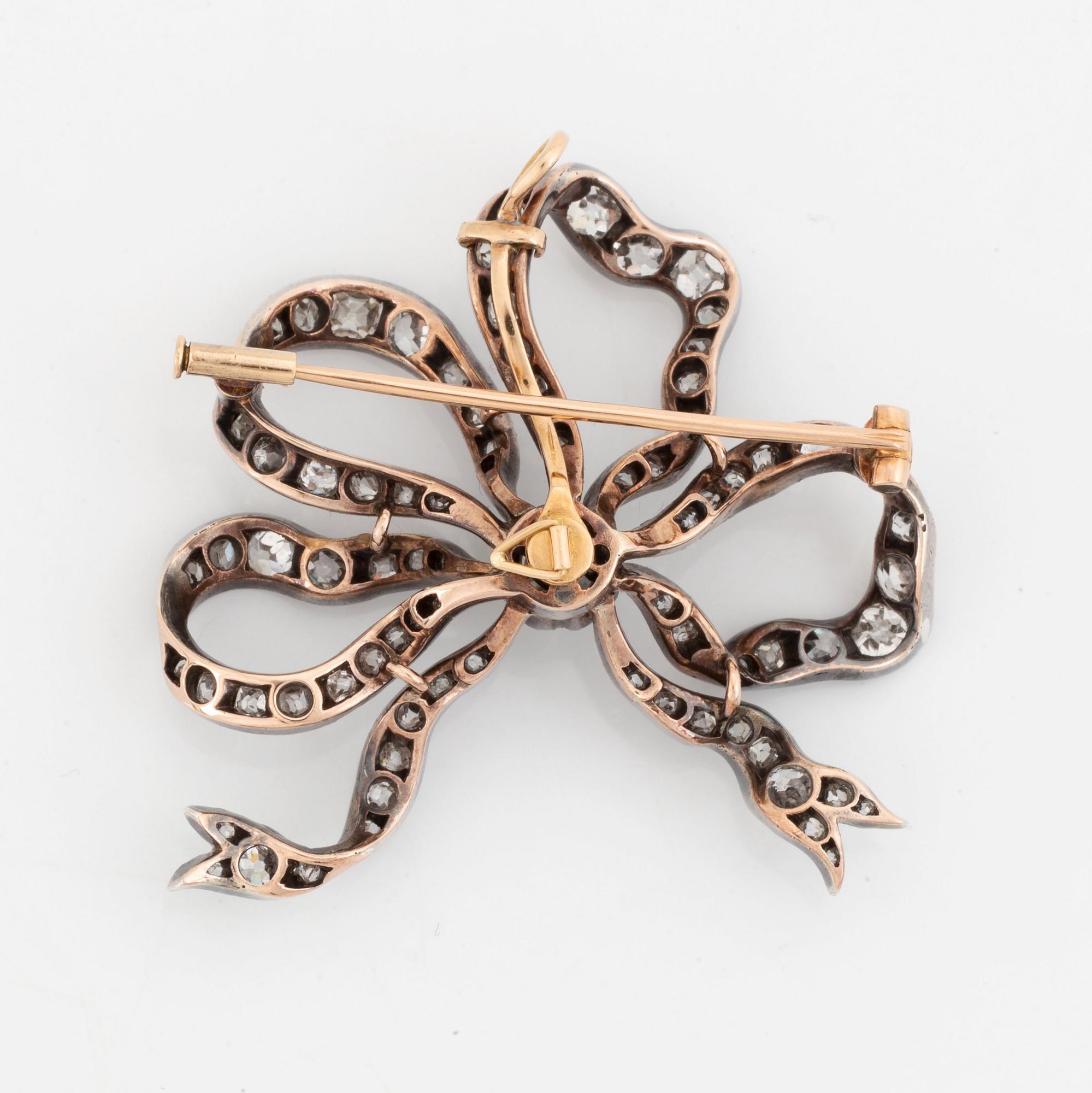 A silver and 14K gold bow brooch/pendant set with old- and rose-cut diamonds.