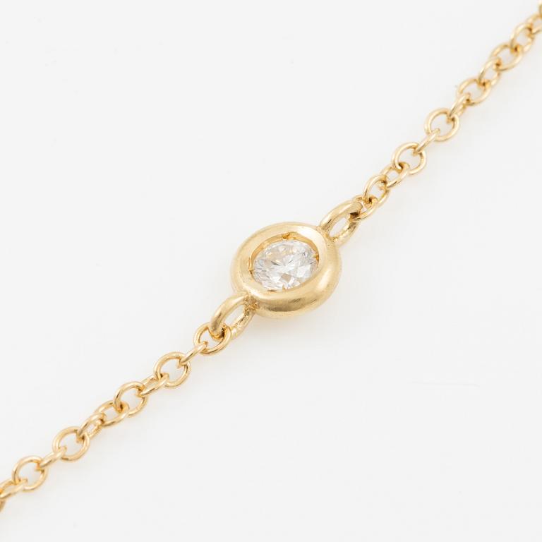 Necklace in 18K gold with a faceted heart-shaped sapphire and round brilliant-cut diamonds.