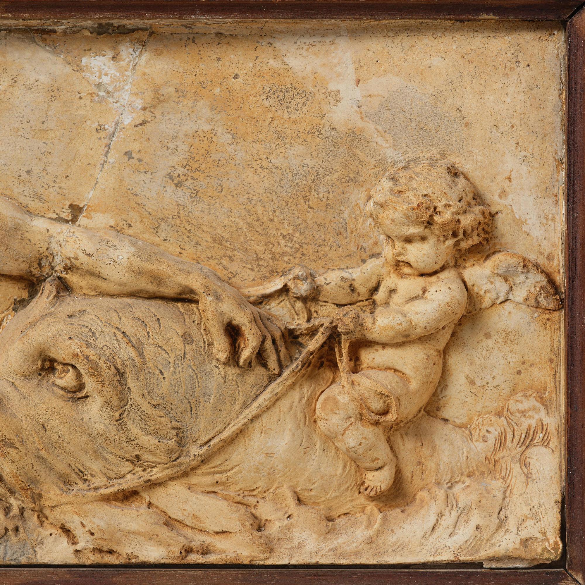 Claude Michel Clodion, attributed to, A relief depicting a nereid riding a dolphin alongside a triton blowing into a conch.