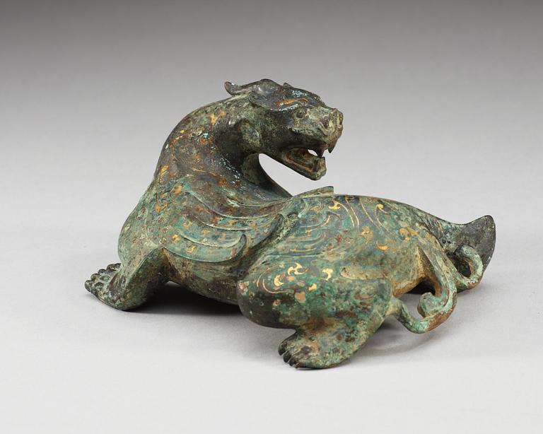 An archaistic bronze figure of a mythological beast.