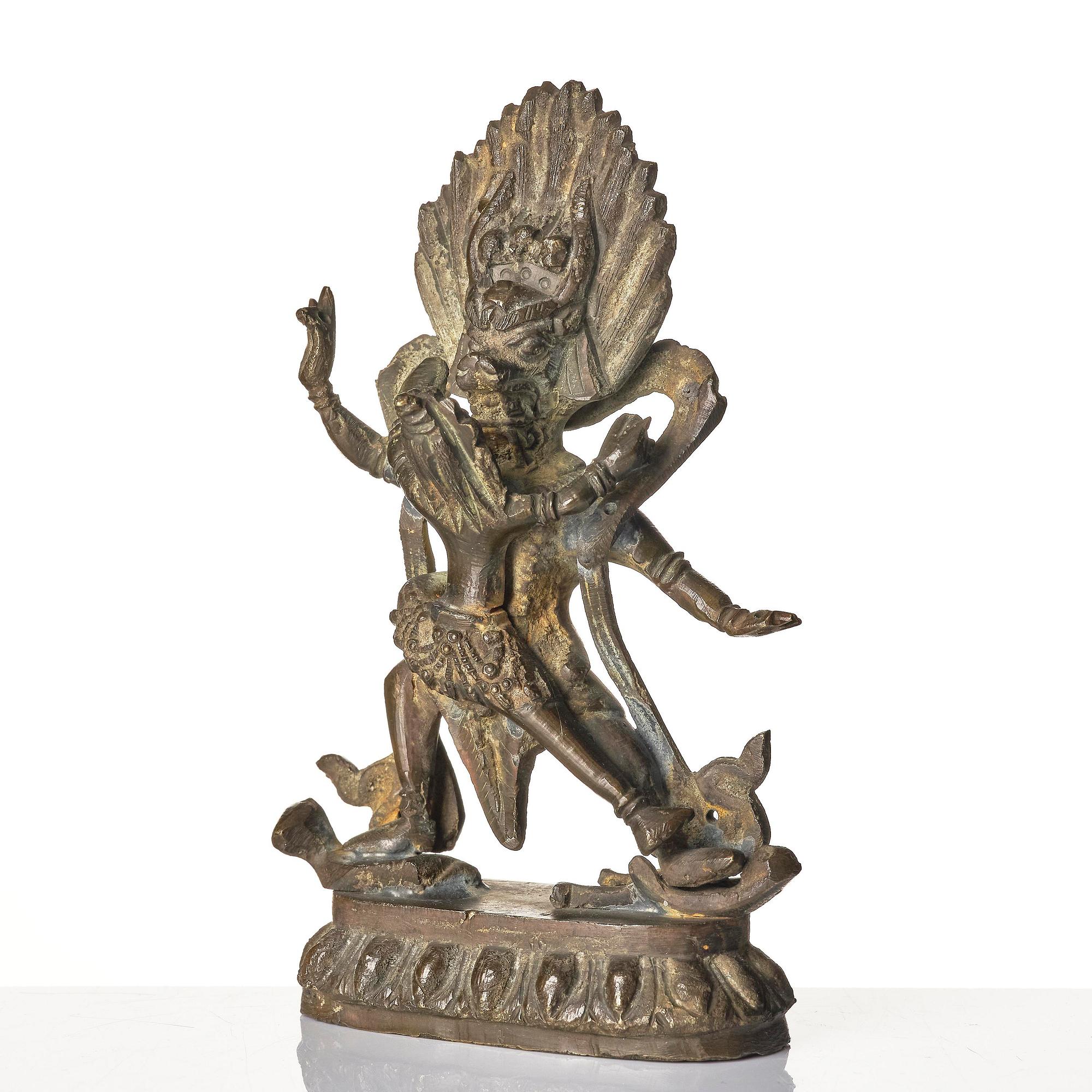 A bronze deity and a brass sacrificial bowl, Tibet, circa 1900.