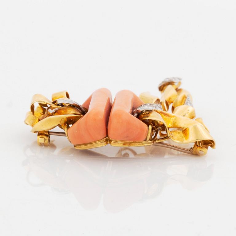 A Kutchinsky brooch in 18K gold set with coral and round brilliant-cut diamonds.