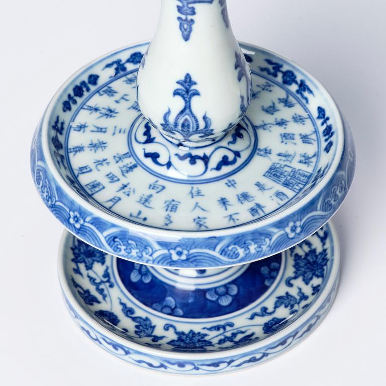 A pair of blue and white pricket candle sticks, with a poem, Qing dynasty with a Qianlong mark and of the period.