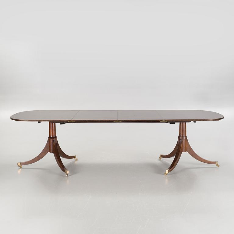 An english style dining table and eight chairs, second half of the 20th century.