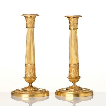 A pair of French Empire ormolu candlesticks, early 19th century.