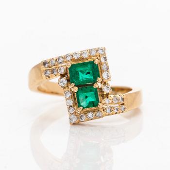 An 18K gold ring with emeralds and diamonds.