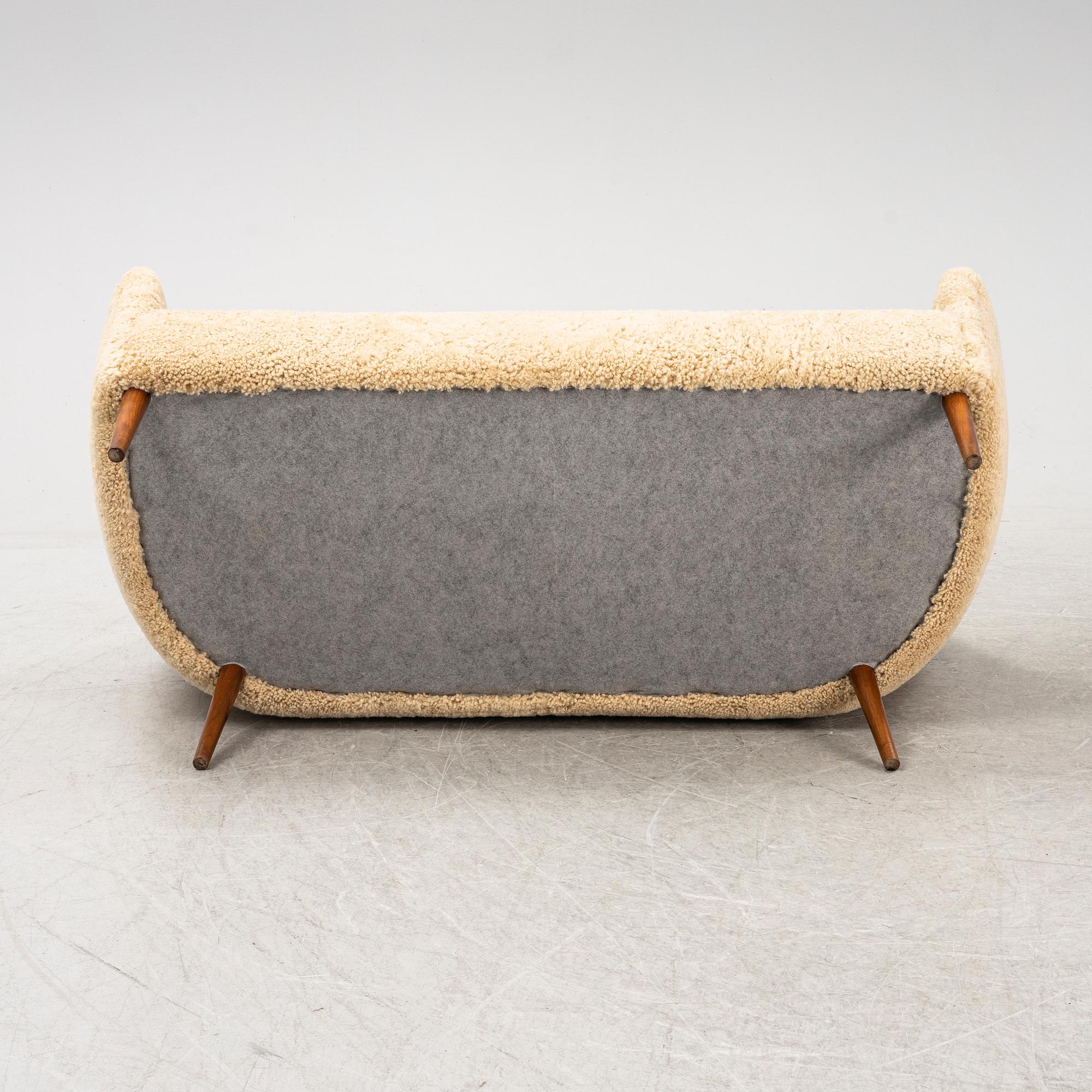 A mid 20th Century sofa with teak legs and new sheepskin upholstery, possibly by Carl Brorup, Slagelse, Denmark.