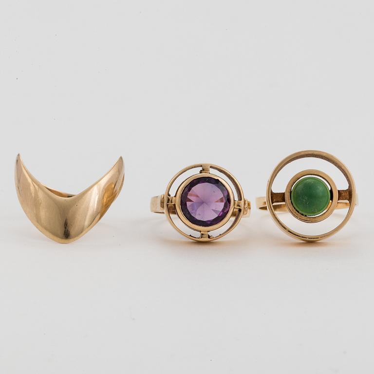 Three 14K gold rings, one with a synthetic, colour-change, sapphire and one with a green stone.